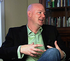 Image of Jake Adam York, sitting and speaking, wearing casual clothing.