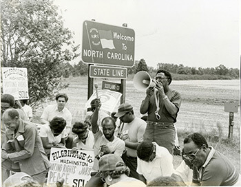 Elaine Tomlin, Joseph Lowery leading a prayer during the 1982 Pilgrimage to Washington for Voting Rights, Peace, Economic Justice, North Carolina, 1982. Courtesy of SCLC records, MARBL, Emory University.
