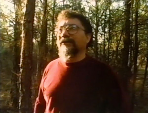 Photograph of Raymond Andrews in the woods, still from Somebody Else, Somewhere Else, 2010.