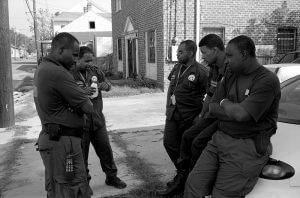 New Orleans police officers, off St. Claude Avenue. New Orleans, Louisiana, October 2005. Photograph by Lewis Watts. Courtesy of Lewis Watts.