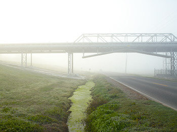 Pipeline and River Road, Donaldsonville, Louisiana, 2010. Photograph by Richard Misrach. Courtesy of Pace/MacGill Gallery, New York; Fraenkel Gallery, San Francisco; and Marc Selwyn Gallery, Los Angeles. © Richard Misrach.