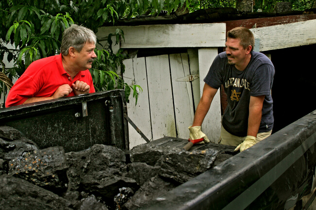Letcher County Judge, Caroll Smith, visits with local resident loading house coal. Letcher County, KY, 2005.