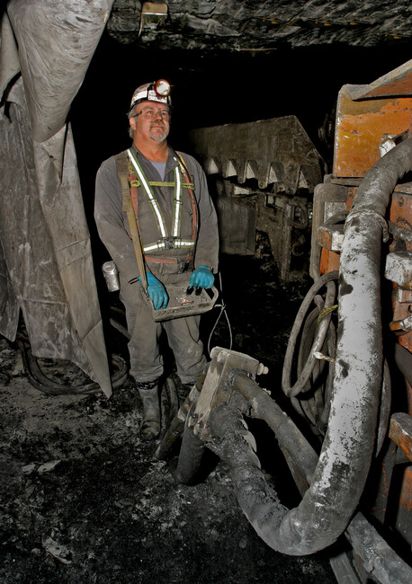 Operator of continuous mining machine uses remote control, keeping him further away from coal dust concentrated at the mine face. Boone County, WV, 2005.