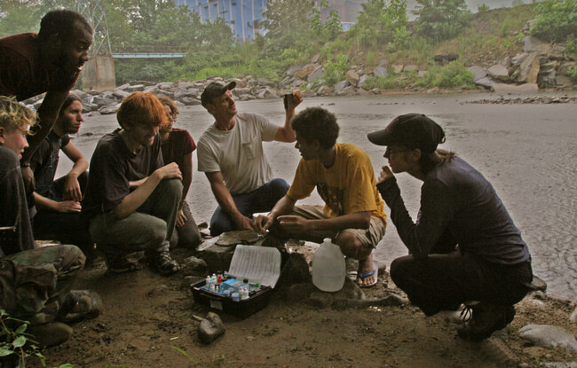 Local community leader (center) works with volunteers to monitor water quality in river bypassing coal mine. Raleigh County, WV, 2005.