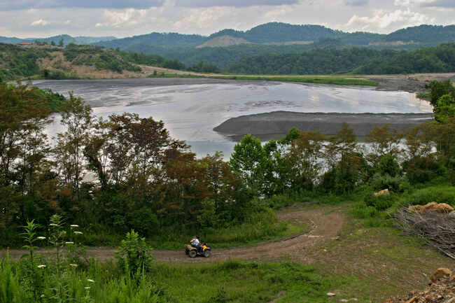 All-Terrain Vehicle (ATV) traverses coal mine waste impoundment access road. Letcher County, KY, 2005.