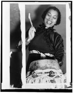 Hurston beating a hountar or mama drum