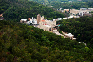 Aerial view of downtown Hot Springs, Arkansas, shows a small city surrounded by forest.