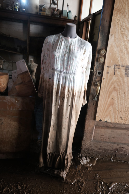 Muddied dress on a headless mannequin in store.